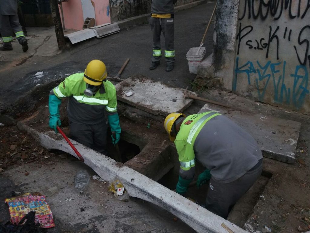 Funcionários realizam limpeza de boca-de-lobo.