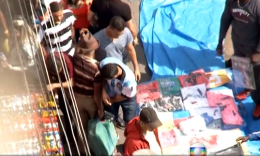 Em ação: ladrão (com camisa da seleção argentina) rouba idoso em meio à multidão. Imagem: TV Globo