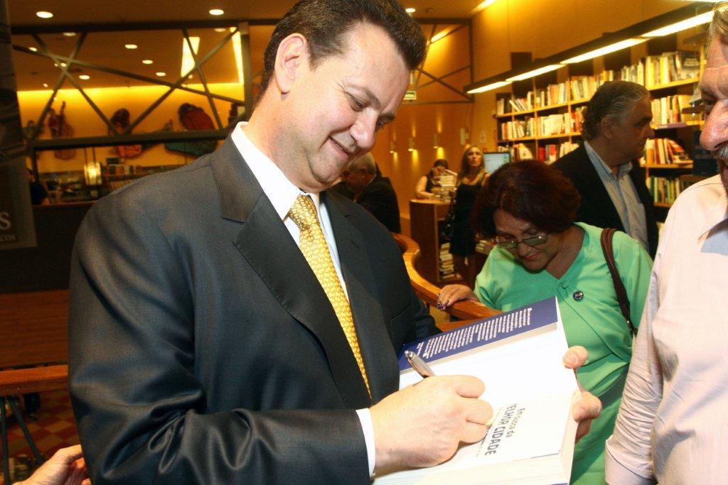 O presidente do PSD, prefeito Gilberto Kassab, autografa livro.